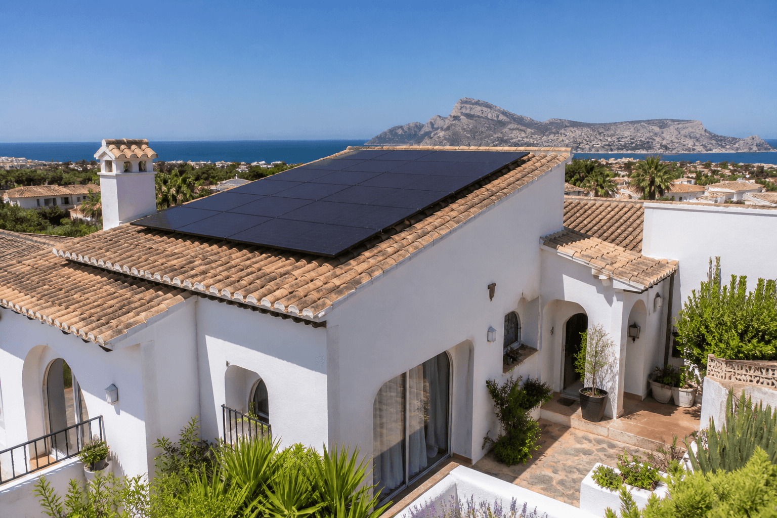 White villa in Spain with rooftop solar panels under a sunny sky